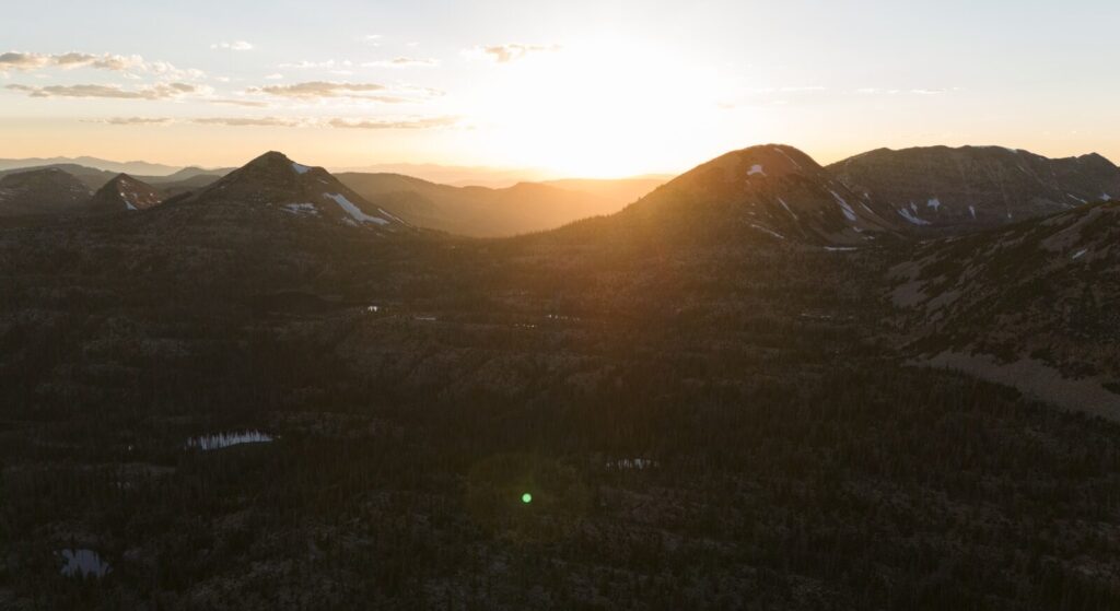 The sun is setting over a mountain range